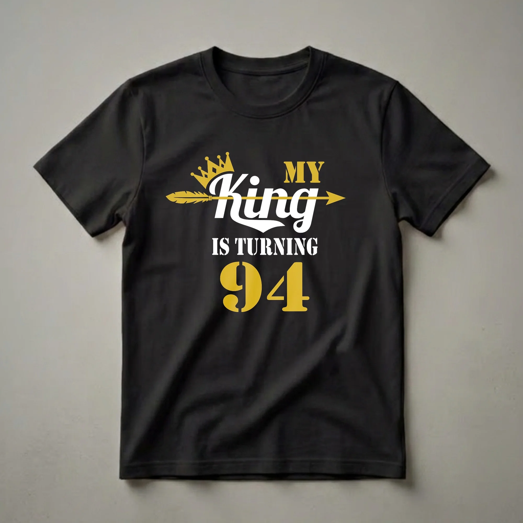 Black t-shirt with white and gold text that reads 'MY King IS TURNING 94', featuring a gold crown and a gold arrow.