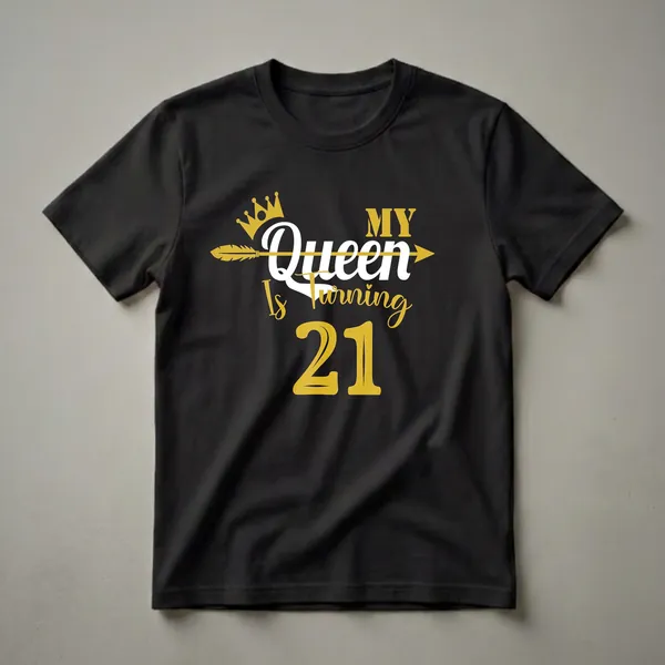 Black t-shirt with gold and white text that reads 'My Queen Is Turning 21', featuring a gold crown and arrow graphic.