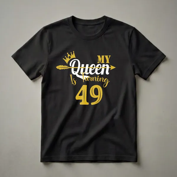 Black t-shirt with gold and white text that reads "MY Queen Is Turning 49" with a gold crown and arrow graphic.