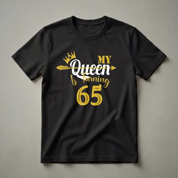 Black t-shirt with gold and white text that reads 'My Queen Is Turning 65' with a crown and arrow graphic.