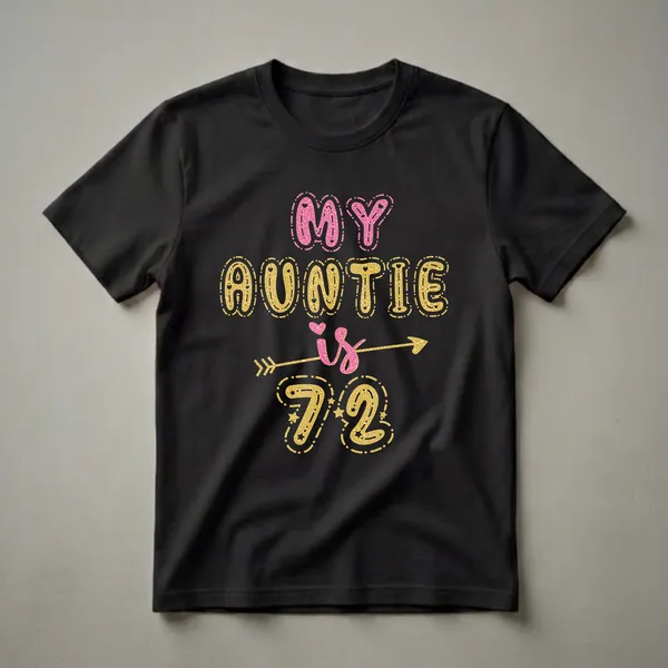 Black t-shirt with the text 'MY AUNTIE IS 72' in pink and gold glittery bubble letters, with a gold arrow and stars.