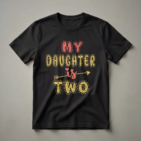 Black t-shirt with the text 'MY DAUGHTER is TWO' in large, glitter-filled bubbly letters. 'MY DAUGHTER' is in red, and 'is TWO' is in gold with a golden arrow.