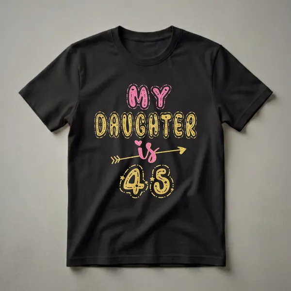 Black t-shirt with pink and gold glittery text that reads 'MY DAUGHTER is 45' with decorative elements like stars and an arrow.