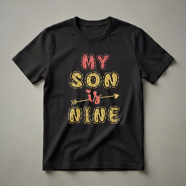 Black t-shirt with "MY SON is NINE" text graphic in gold and red glitter effect, featuring an arrow through the word 'is'.