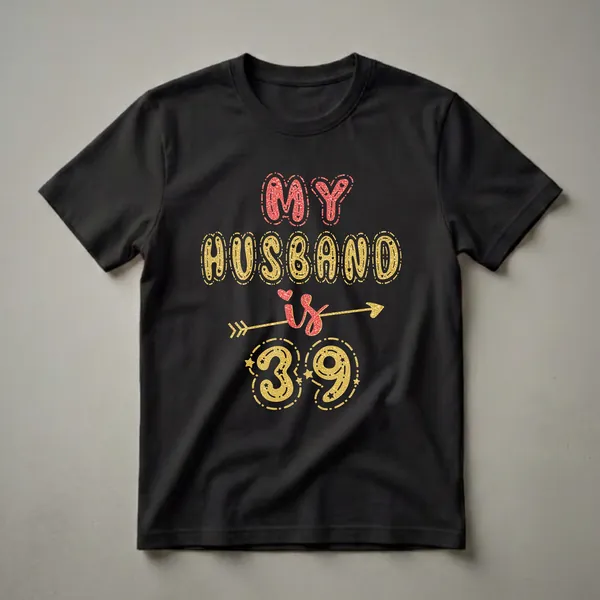 Black t-shirt with gold and red glitter text that reads 'MY HUSBAND is 39' with an arrow and stars.