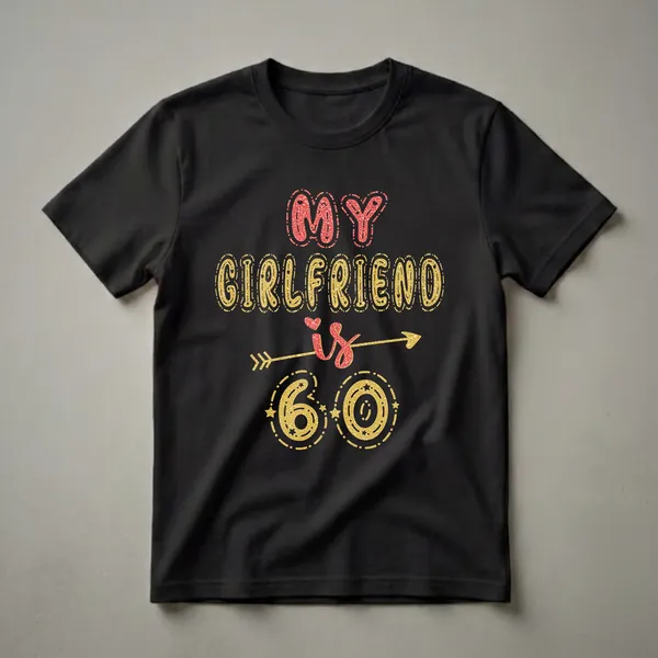 Black t-shirt with glittery red and gold text that reads "MY GIRLFRIEND is 60" with an arrow and decorative elements.