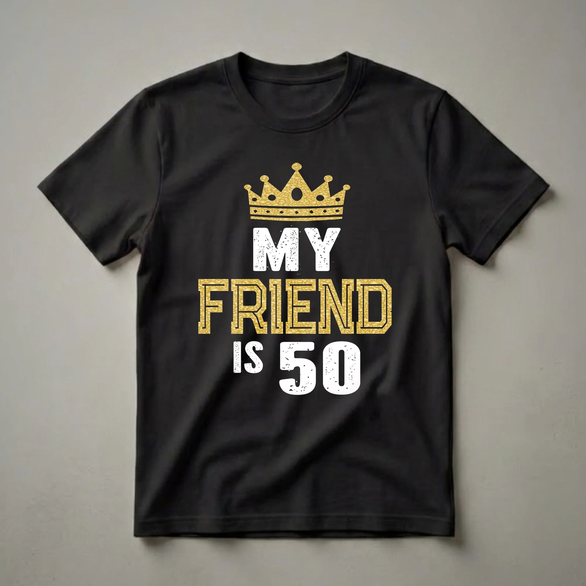 Black t-shirt with a gold glitter crown graphic and distressed white text reading 'MY' and 'IS 50', and gold textured text reading 'FRIEND'.