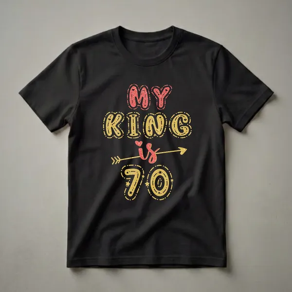 Black t-shirt with 'MY KING is 70' text graphic in red and gold glitter with hearts and stars.