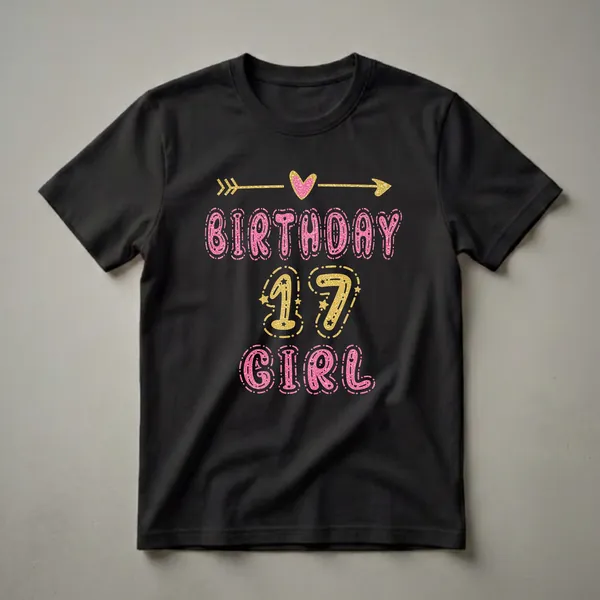 Black t-shirt with pink glittery letters spelling "BIRTHDAY GIRL" and gold glittery numbers "17" with stars and decorative elements.
