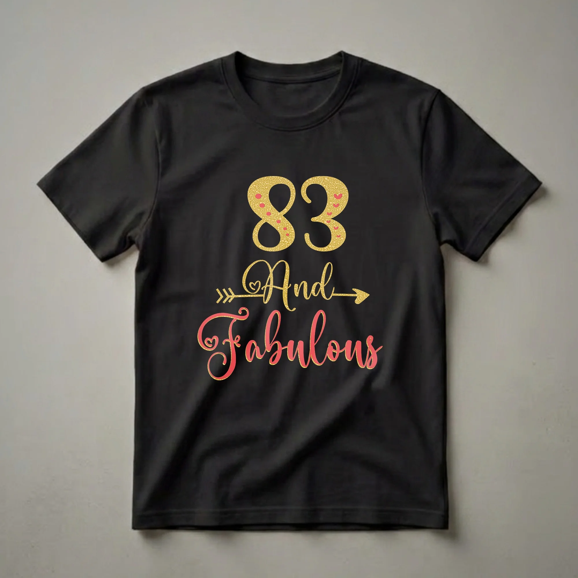 Black t-shirt with gold glitter '83' and coral script 'And Fabulous' with gold glitter outline and heart accents.