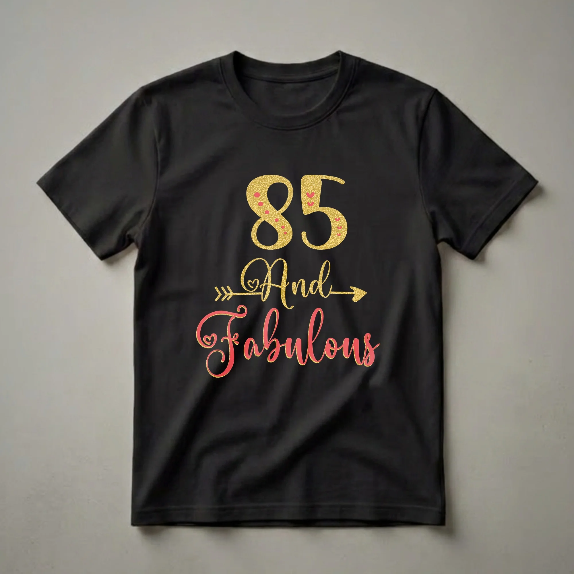 Black t-shirt with gold glitter '85' and coral script 'And Fabulous' with gold glitter outline and accents, for an 85th birthday celebration.