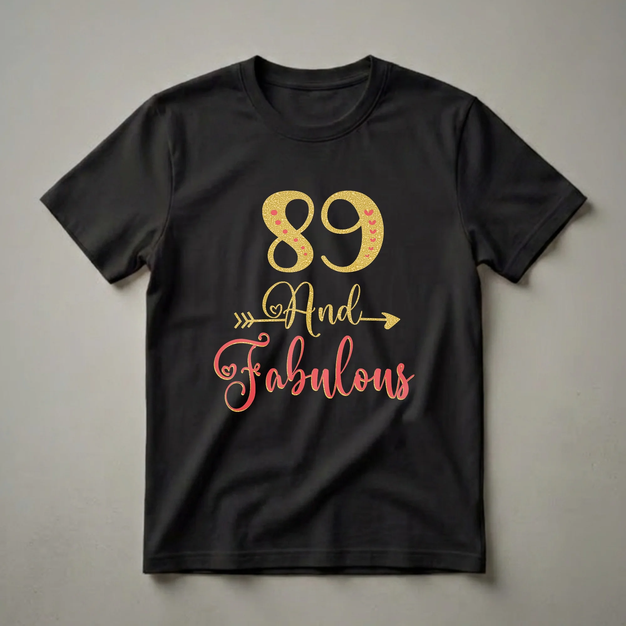 Black t-shirt with gold glitter '89' and coral script 'And Fabulous' with arrow accents, celebrating an 89th birthday.
