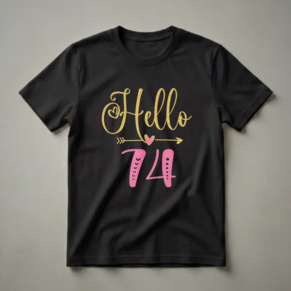 Black t-shirt with gold glitter text 'Hello' and pink glitter numbers '74' with decorative hearts and arrows, for women's 74th birthday.