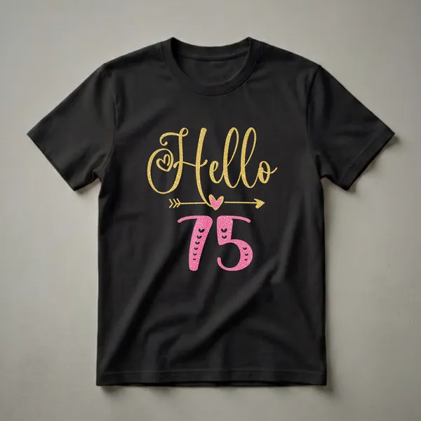 Black t-shirt featuring the text 'Hello 75' in gold glitter and pink textured fonts, with heart and arrow graphic elements.