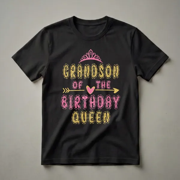 Black t-shirt with glittery gold and pink text that reads 'GRANDSON OF THE BIRTHDAY QUEEN', topped with a pink crown and accented with a gold arrow and heart.
