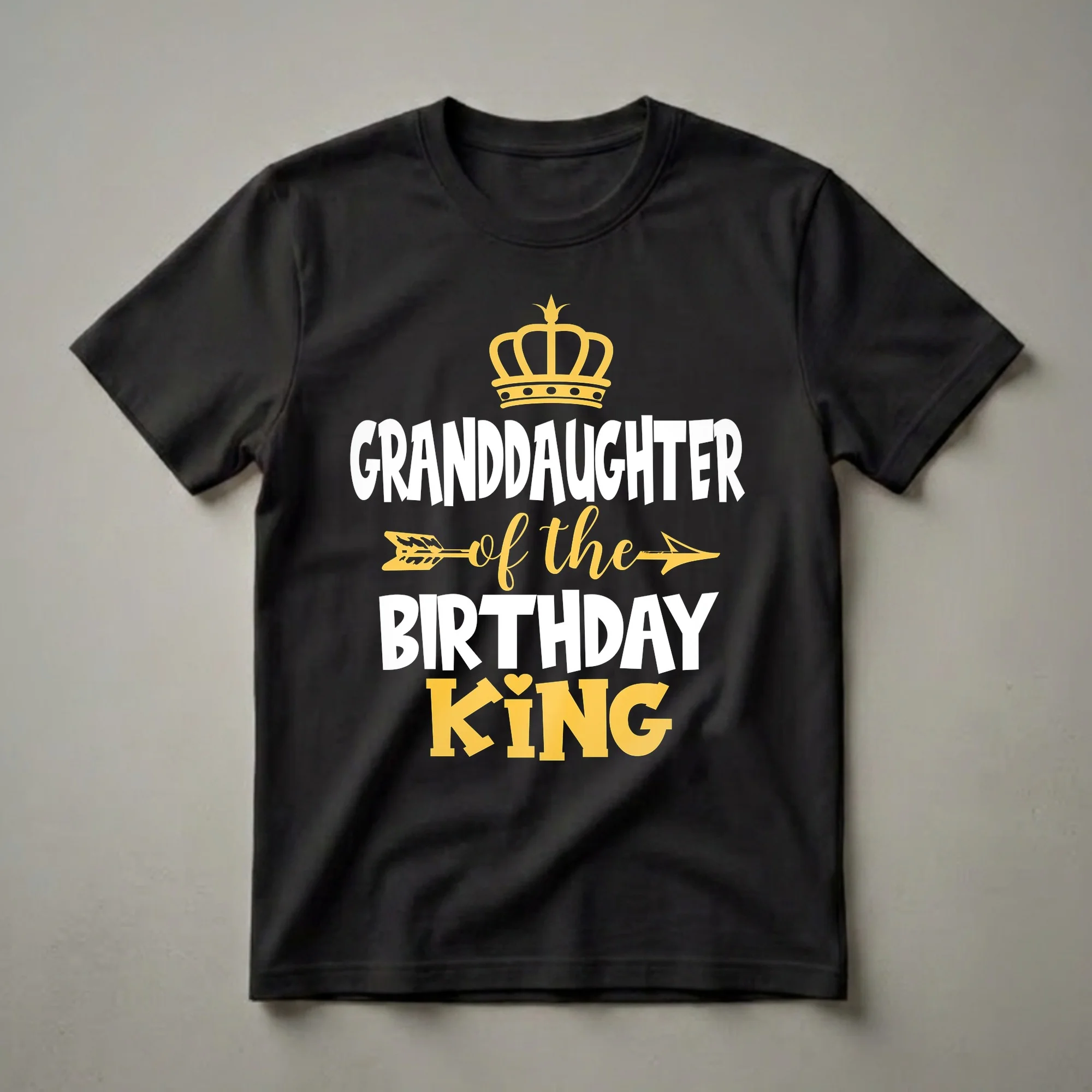 Black t-shirt with white and yellow text that reads 'Granddaughter of the Birthday King', featuring a yellow crown and arrow graphic.