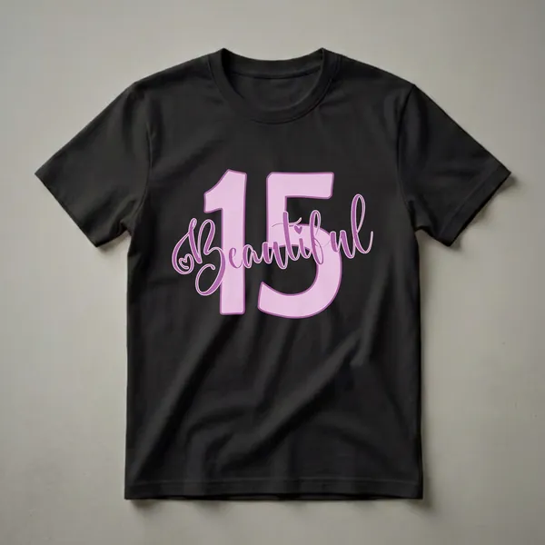 Pink graphic t-shirt with the number 15 and the word 'Beautiful' in cursive script, featuring a small heart detail, for a 15th birthday celebration.