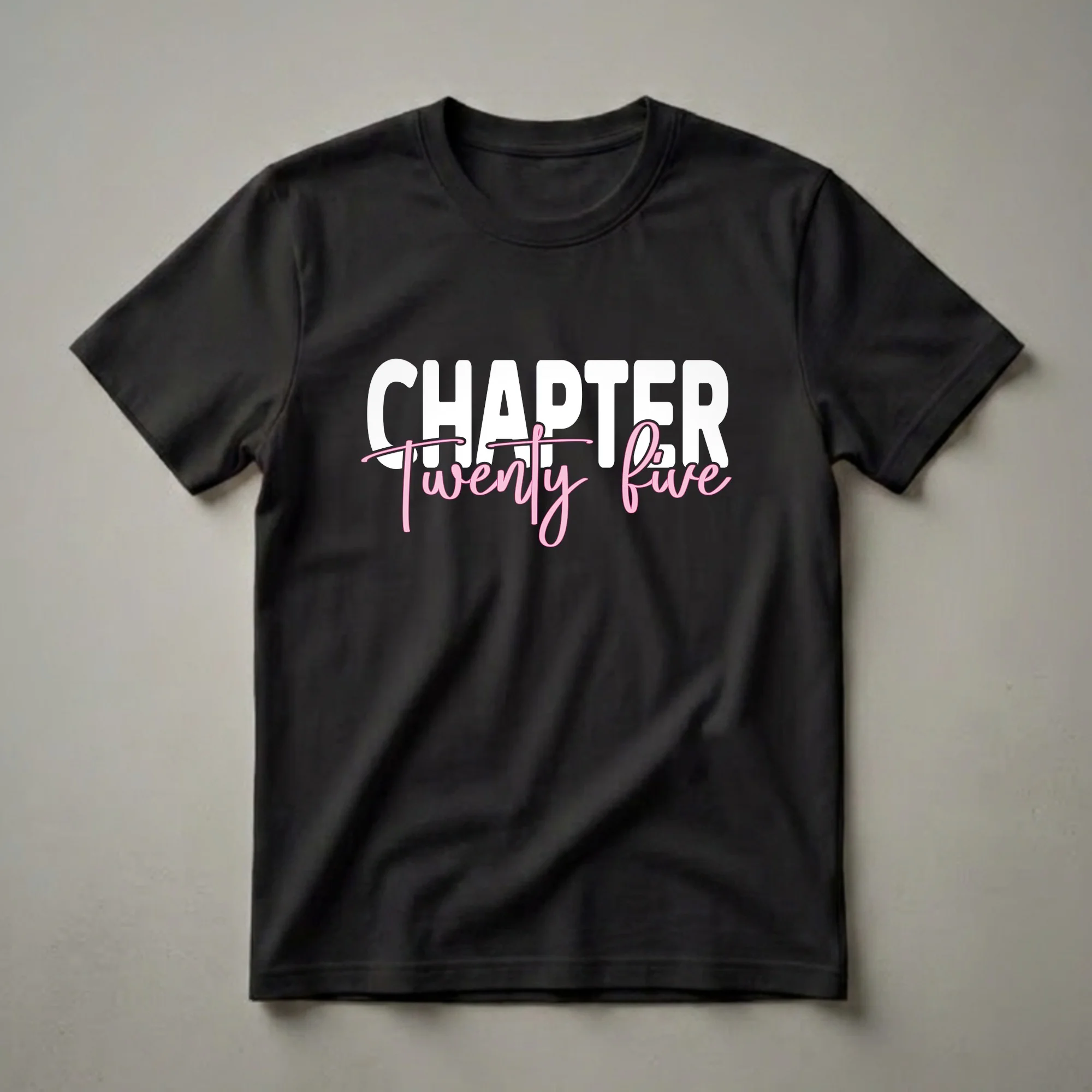 Black t-shirt with white text 'CHAPTER' and pink script text 'twenty five' for a 25th birthday celebration.
