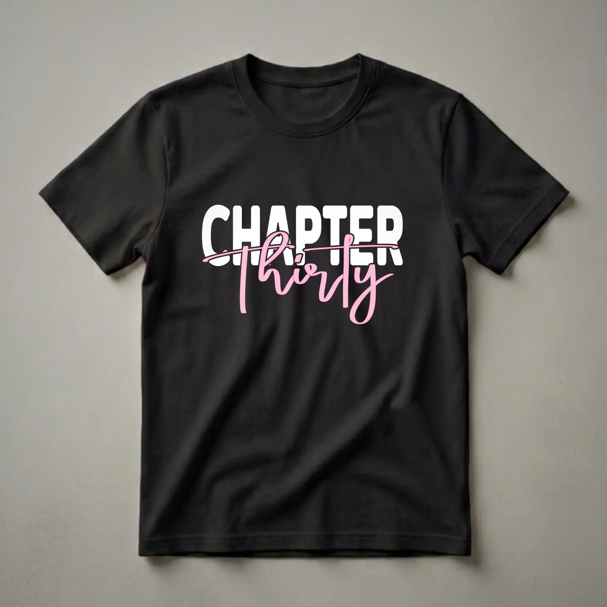 Black t-shirt with white block letters spelling 'CHAPTER' and pink script text reading 'thirty' below it, celebrating a 30th birthday.