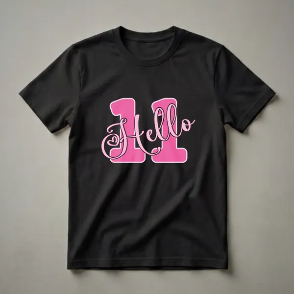 Black t-shirt with a large pink graphic that says 'Hello 11' in a playful font with a small heart detail.