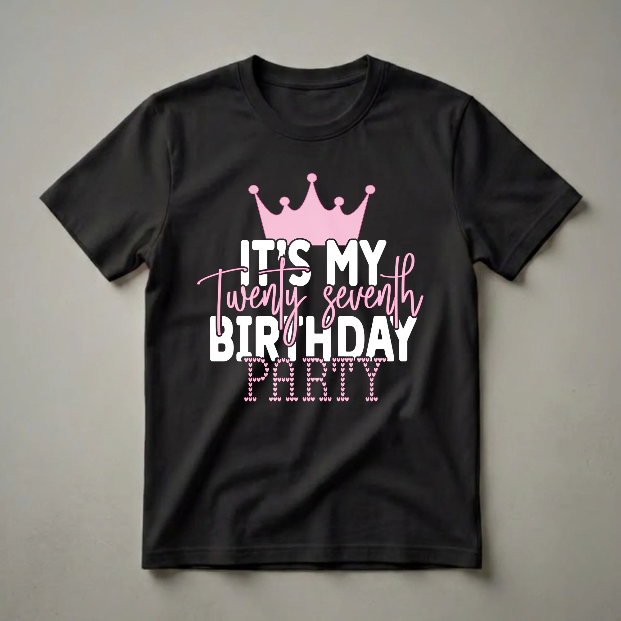 Black t-shirt with white and pink text that reads 'IT'S MY Twenty seventh BIRTHDAY PARTY', topped with a pink crown and decorated with pink hearts.