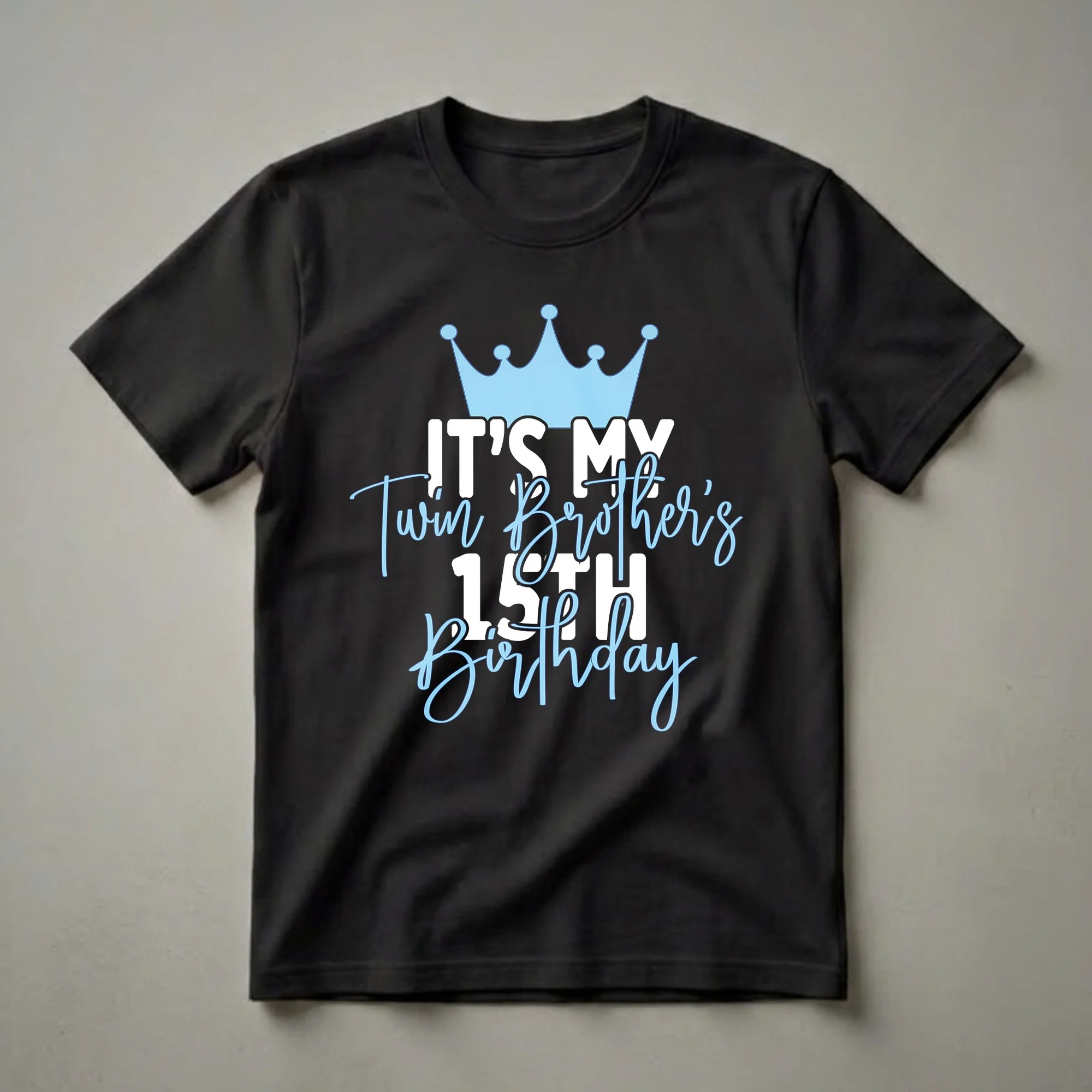 Black t-shirt with a light blue crown graphic and white and light blue text that reads 'IT'S MY Twin Brother's 15TH Birthday'.