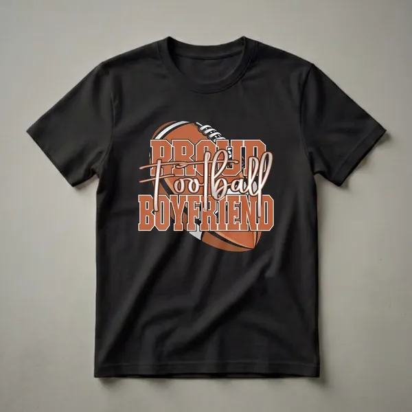Black t-shirt with a graphic design that reads 'Proud Football Boyfriend' in orange and white, layered over a football.