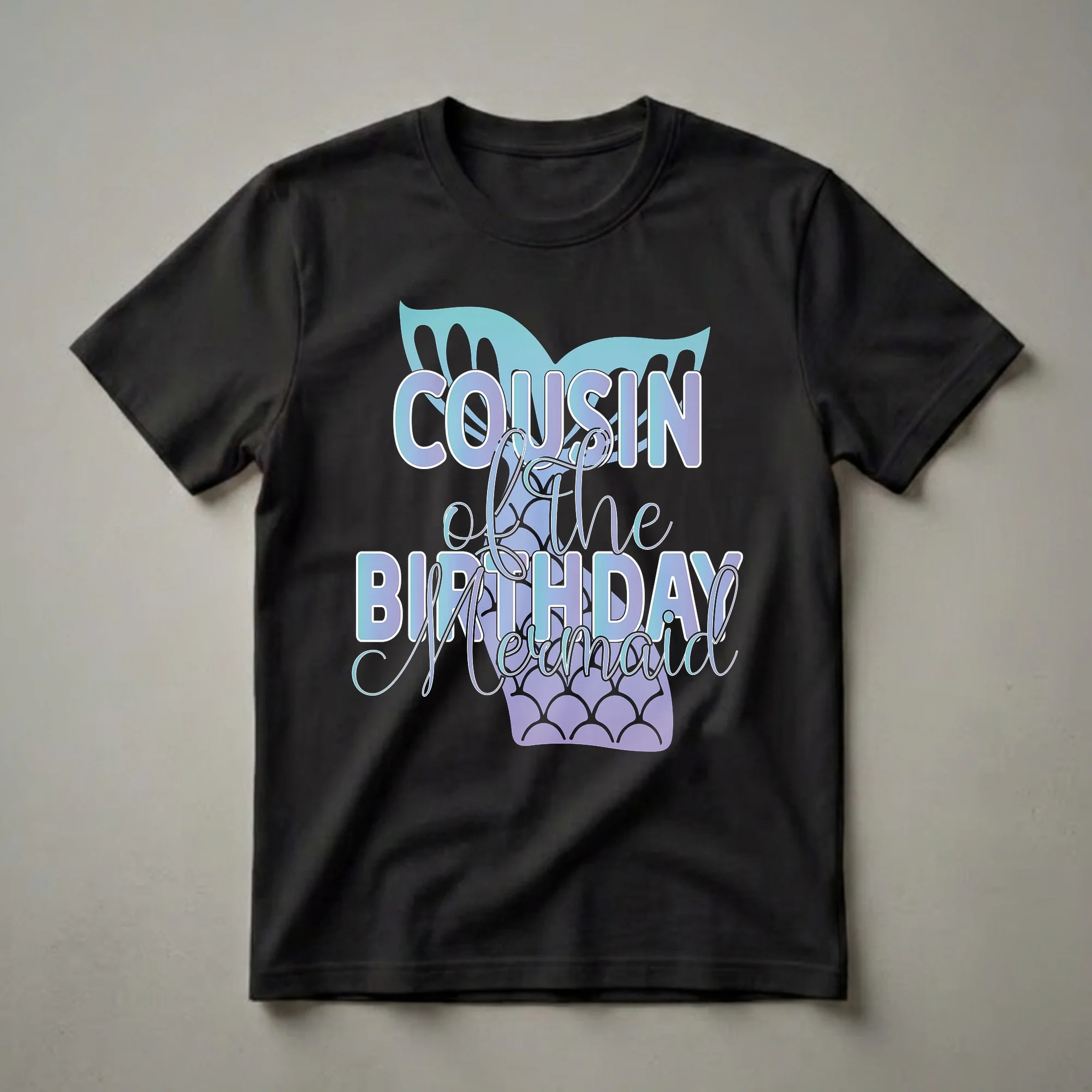A black t-shirt graphic featuring the text 'Cousin of the Birthday Mermaid' in gradient blue and purple lettering, with a teal and purple mermaid tail and fins.