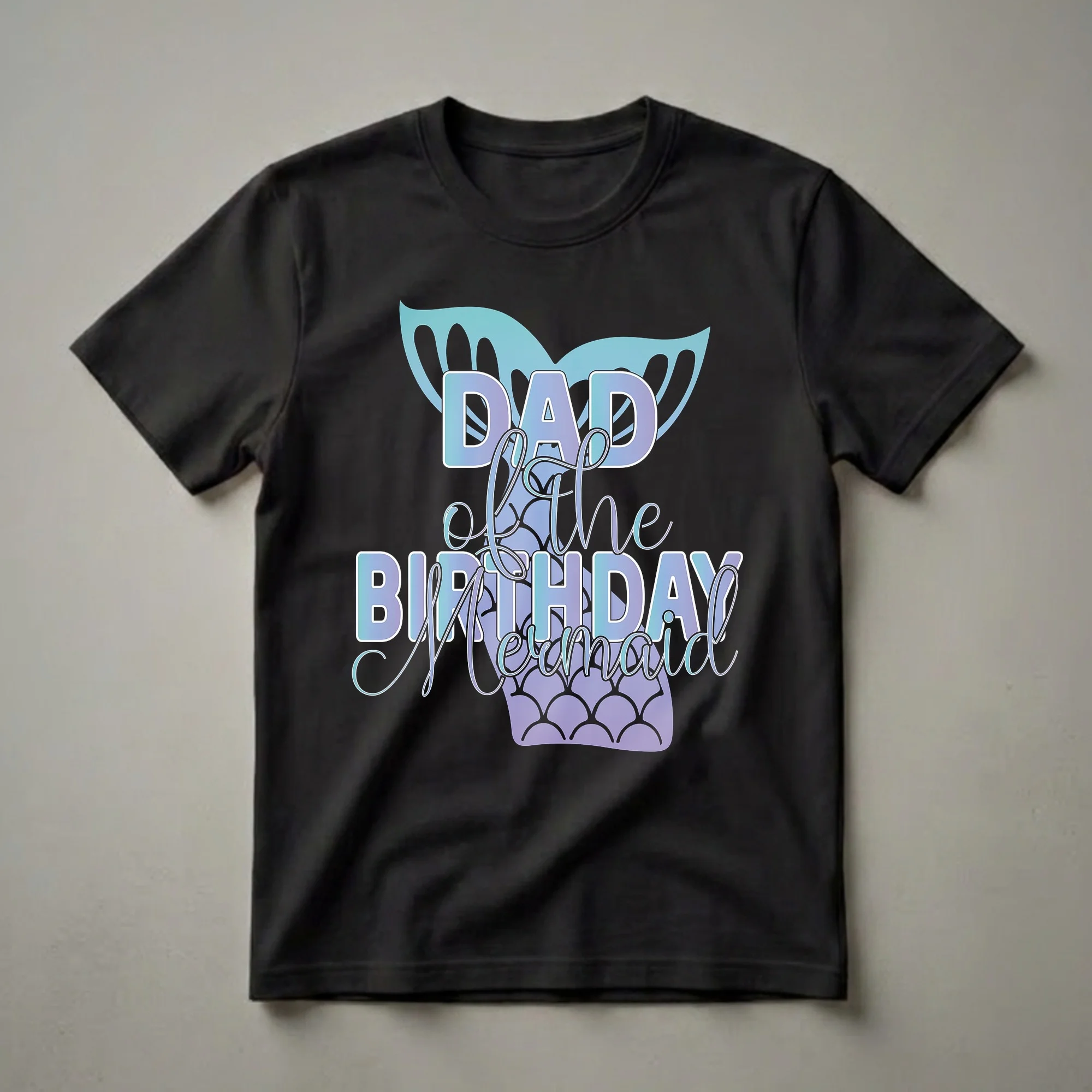 Black t-shirt with 'Dad Of The Birthday Mermaid' text in blue and purple gradient, featuring a teal mermaid fin and a purple mermaid tail graphic.