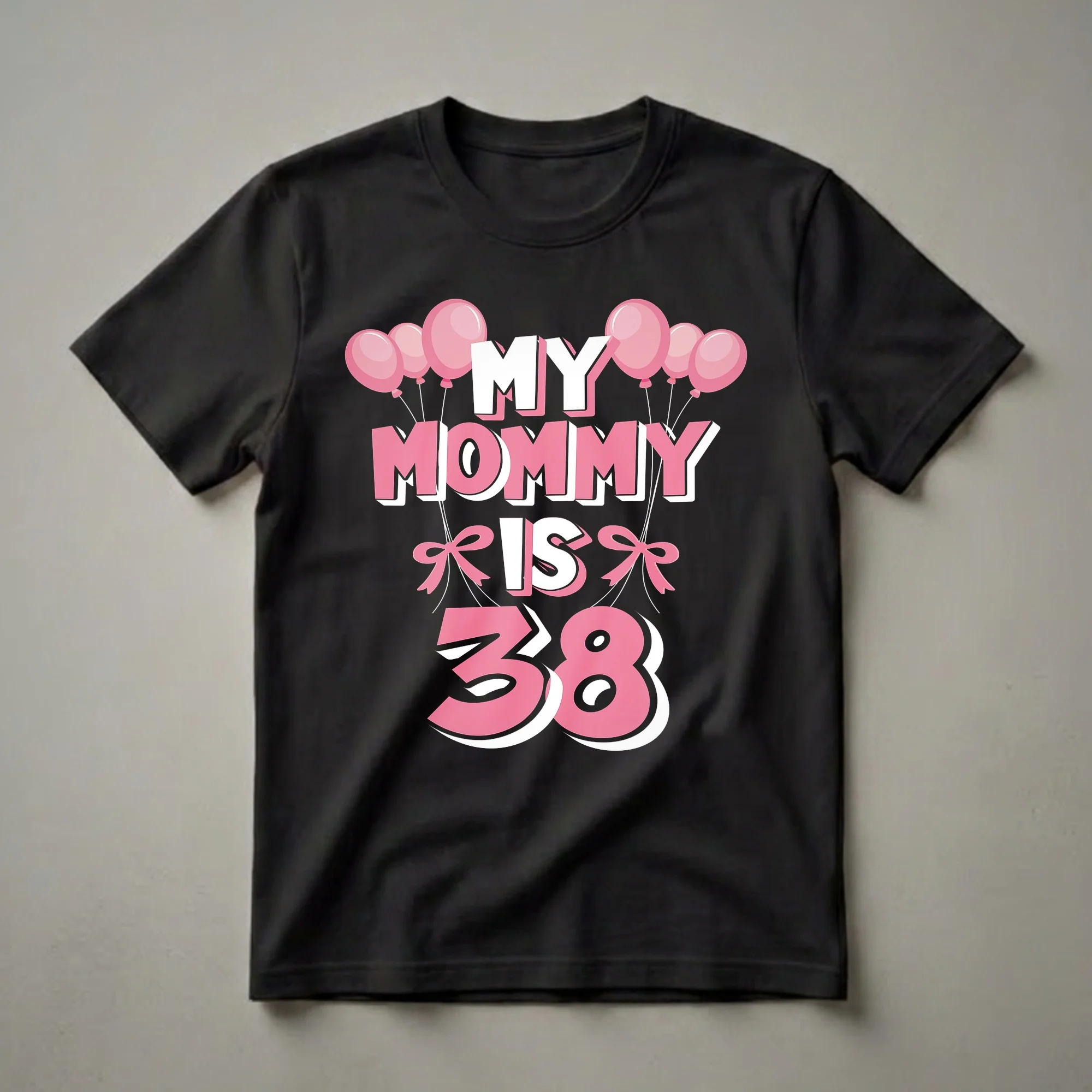 Black t-shirt with pink and white text that reads "MY MOMMY IS 38" surrounded by pink balloons and pink bows, celebrating a 38th birthday.