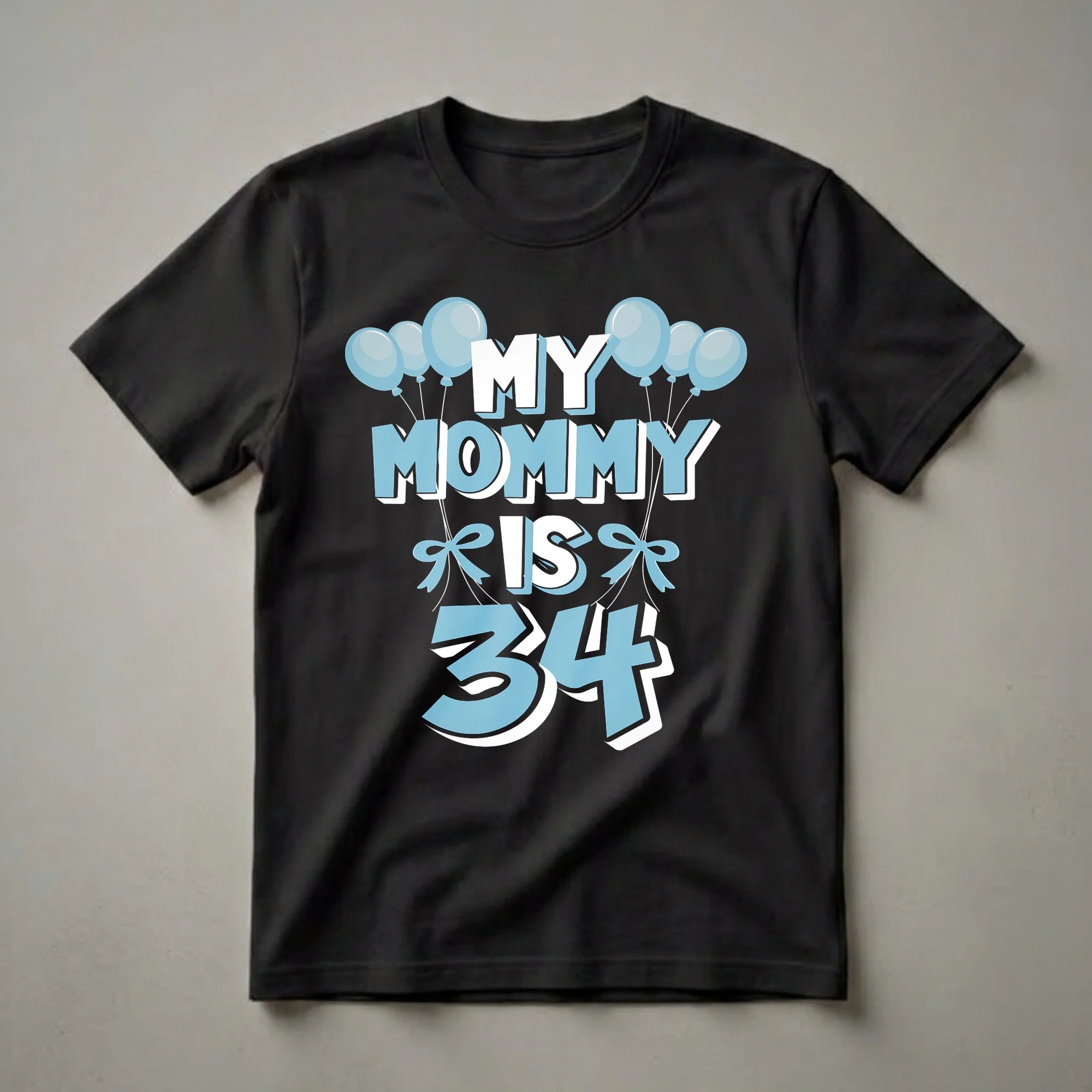 A black t-shirt with the text 'MY MOMMY IS 34' in white and light blue, adorned with light blue balloons and bows.
