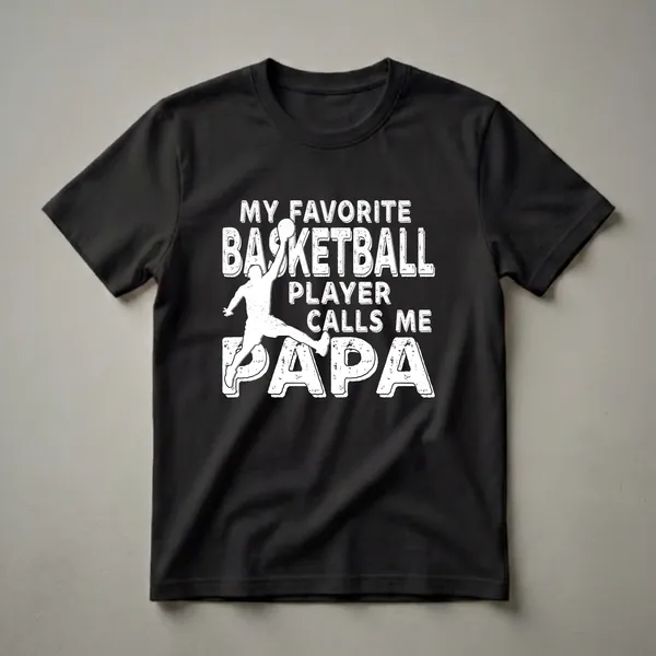 Black t-shirt with distressed white all-caps text reading MY FAVORITE BASKETBALL PLAYER CALLS ME PAPA and a white basketball player silhouette mid-jump.