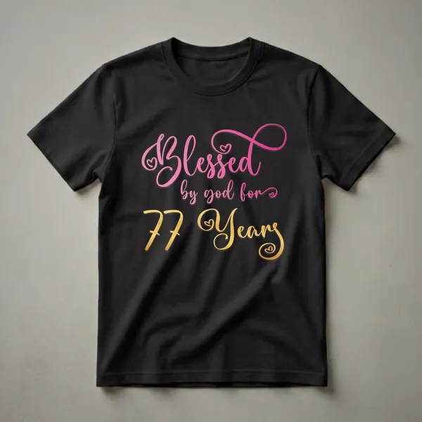 Black t-shirt with the text 'Blessed by God for 77 Years' in pink and gold gradient cursive fonts, celebrating a 77th birthday.