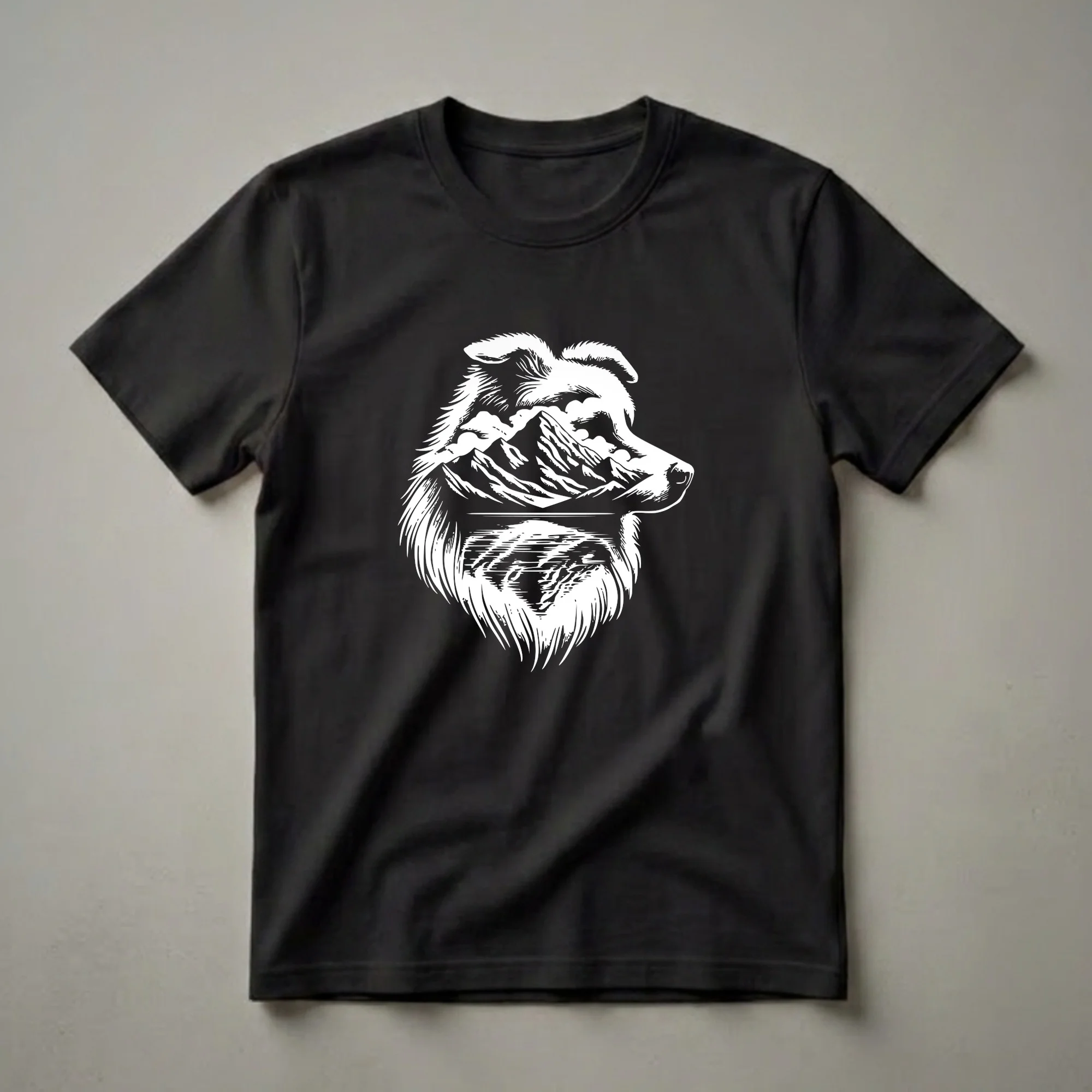 White graphic design of an Australian Shepherd dog's head filled with a mountain range and a lake, printed on a dark t-shirt.
