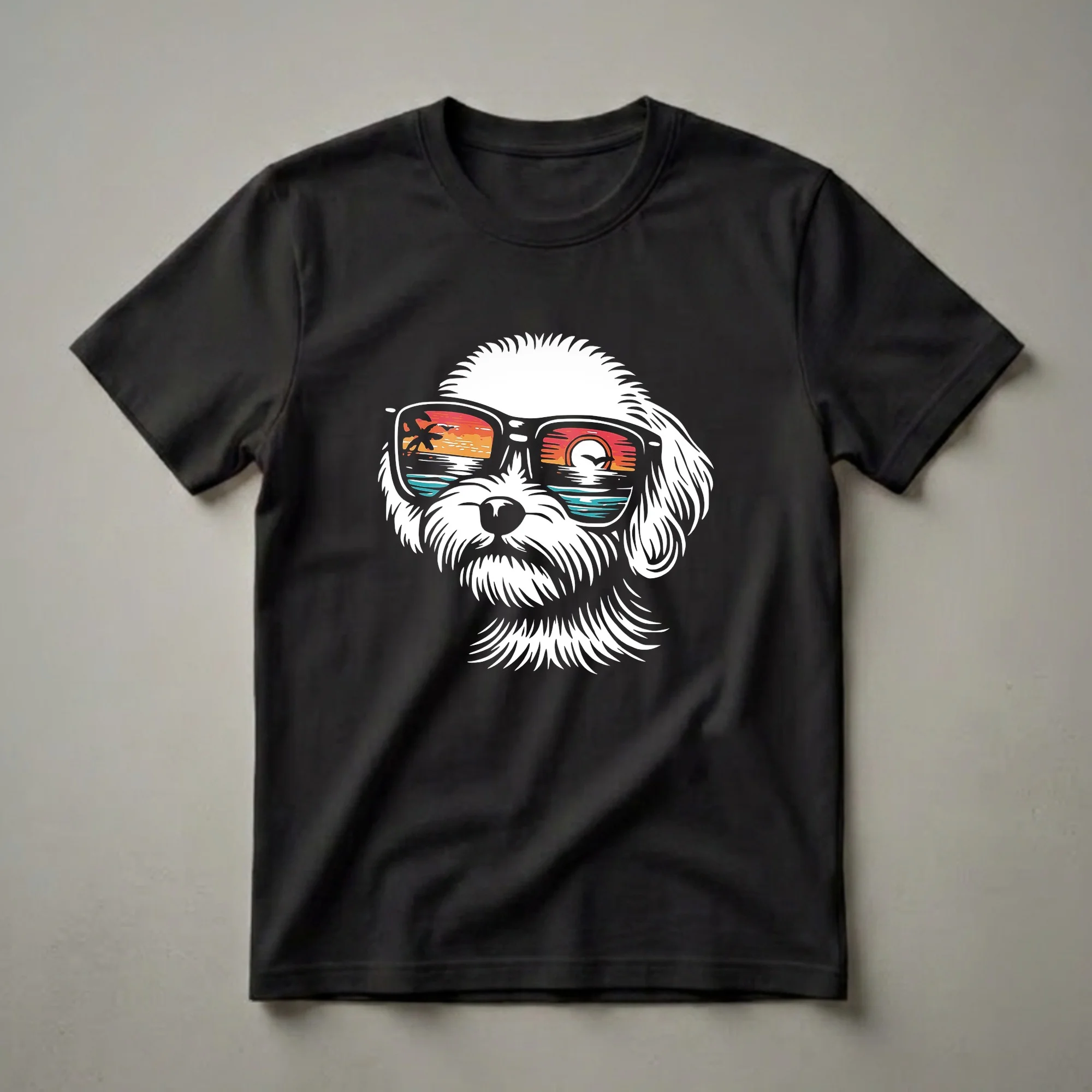White Maltipoo puppy wearing black sunglasses with a colorful sunset beach scene reflected in the lenses, on a black t-shirt.