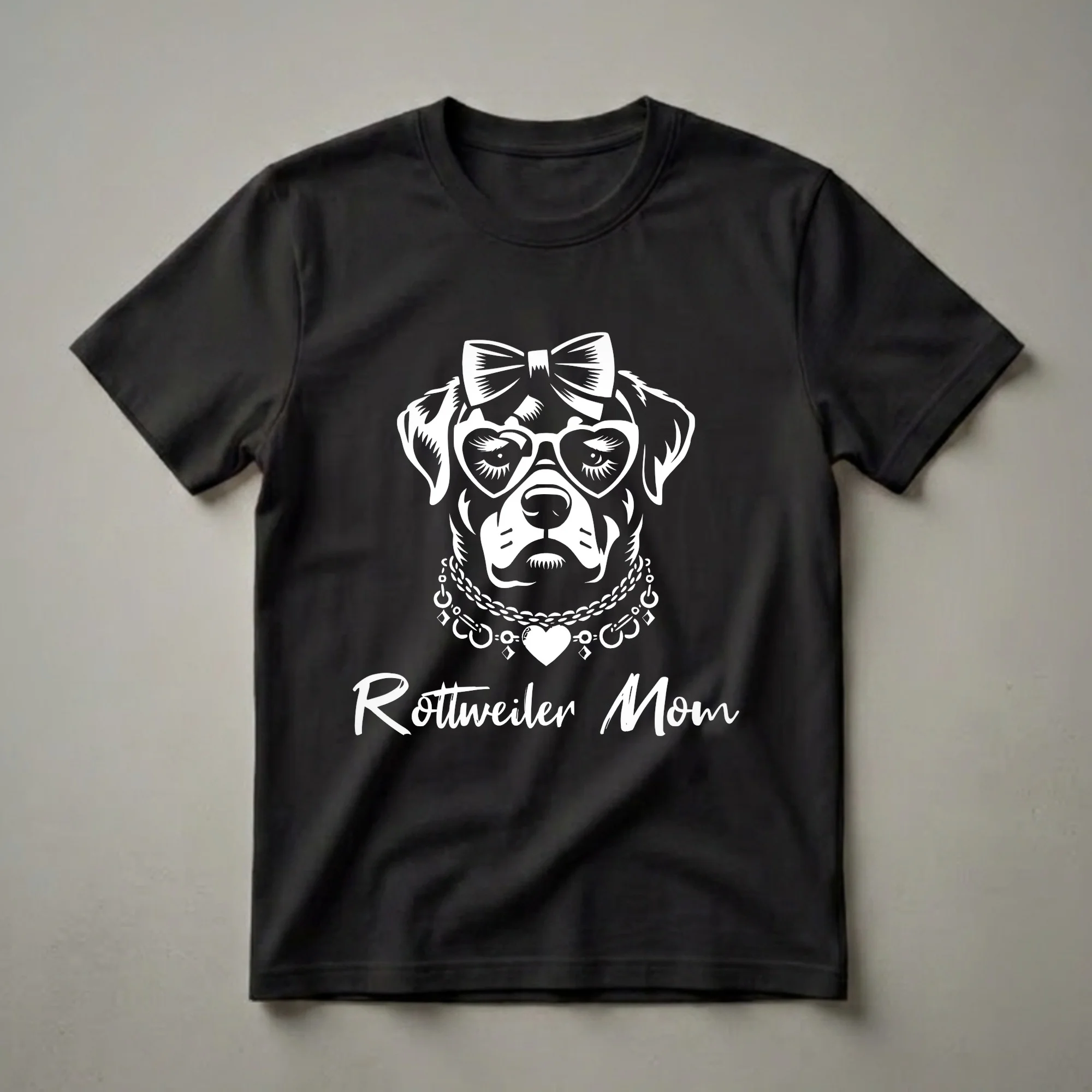 White graphic of a Rottweiler wearing a bow, heart-shaped glasses, and a beaded necklace, with the text 'Rottweiler Mom' below, on a black t-shirt.