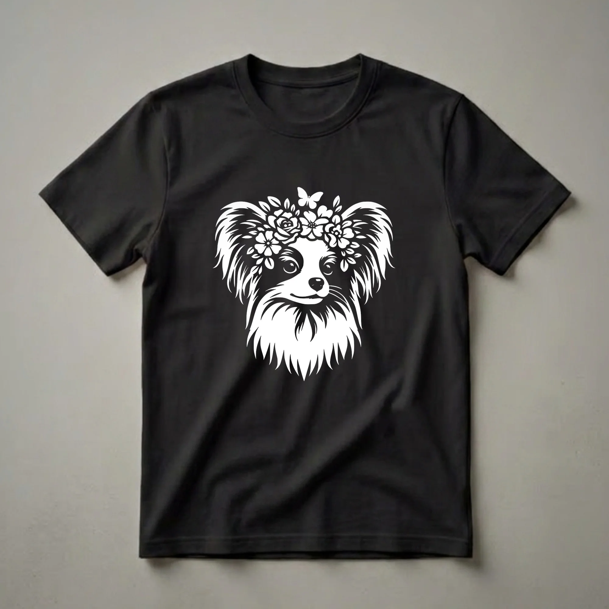 White graphic of a Papillon dog wearing a floral crown with a butterfly, on a black t-shirt.