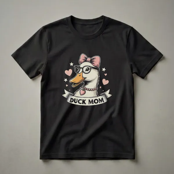 Black t-shirt featuring a cartoon duck wearing glasses and a pink bow, with the text 'DUCK MOM' on a banner below, surrounded by hearts and stars.