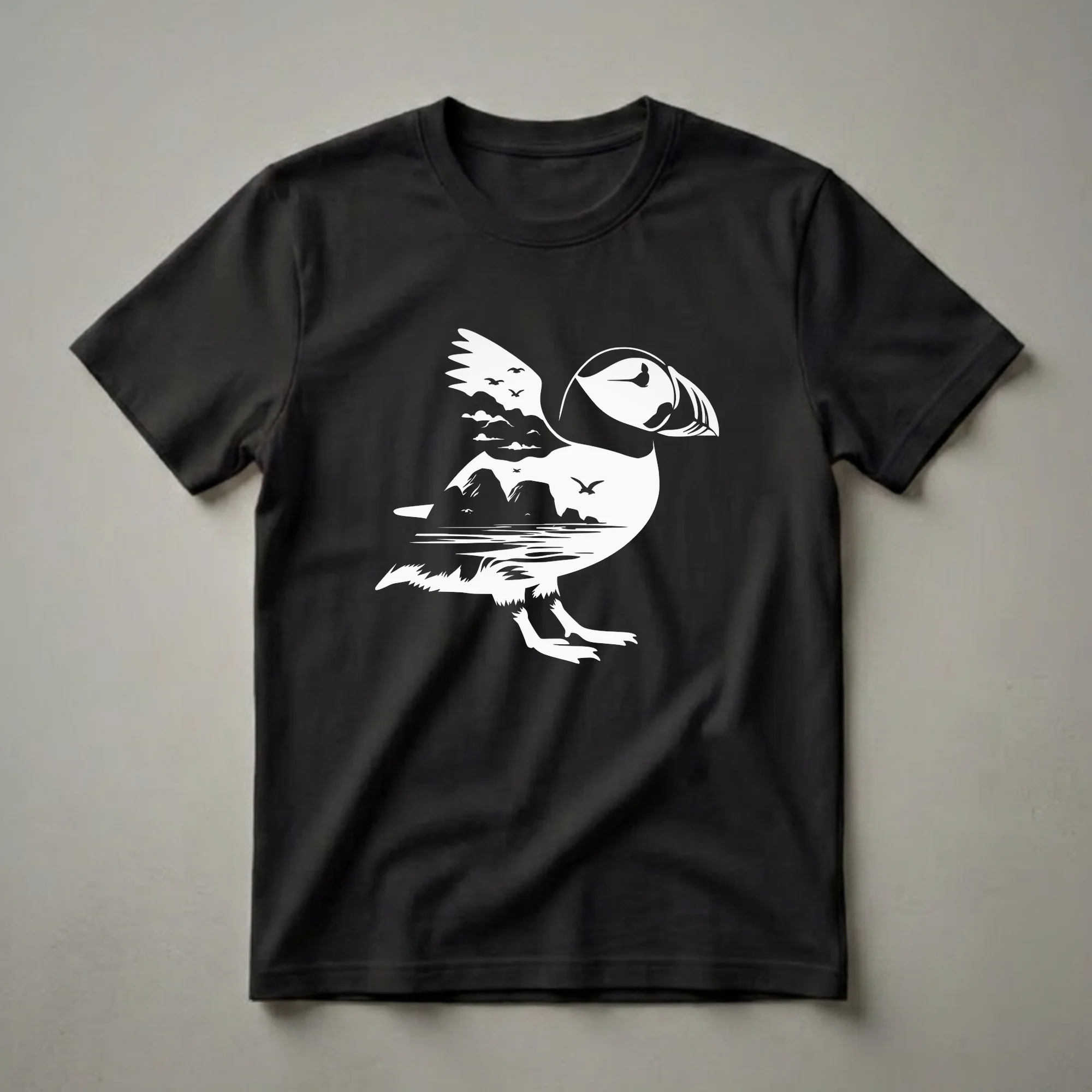 White graphic of a puffin with a landscape scene including rocky islands, water, clouds, and flying birds, printed on a black t-shirt.
