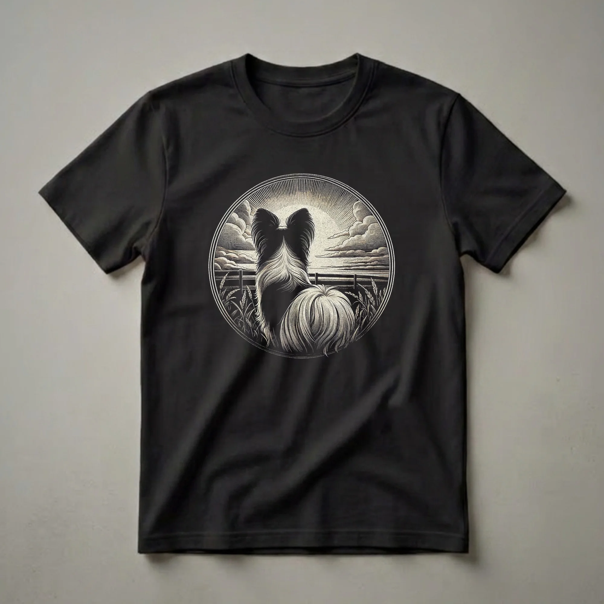 Black t-shirt featuring a vintage-style graphic art design of a Papillon dog's back and tail, looking out over a rural landscape with a fence and wheat fields under a sunburst sky.
