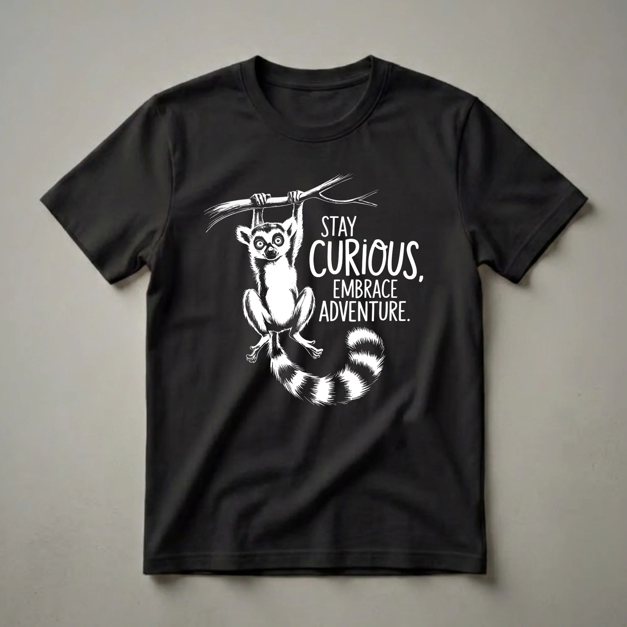 White graphic of a ring-tailed lemur hanging from a branch, with the text 'STAY CURIOUS, EMBRACE ADVENTURE.' on a black t-shirt.