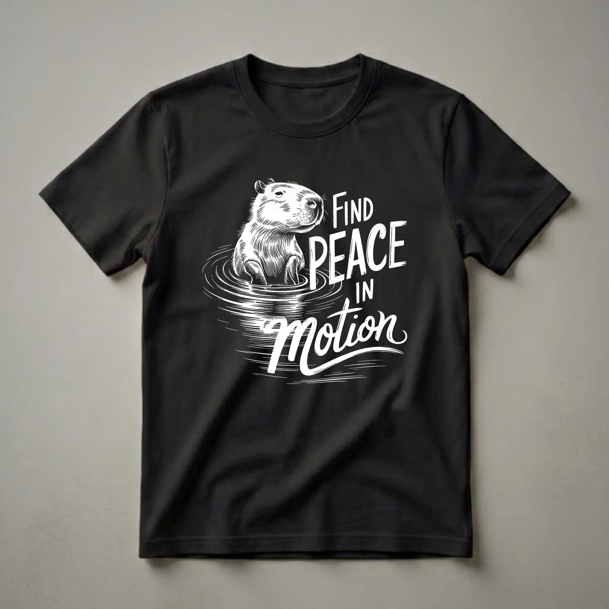 White graphic t-shirt featuring a capybara in water with the text 'FIND PEACE IN Motion' in distressed white lettering.