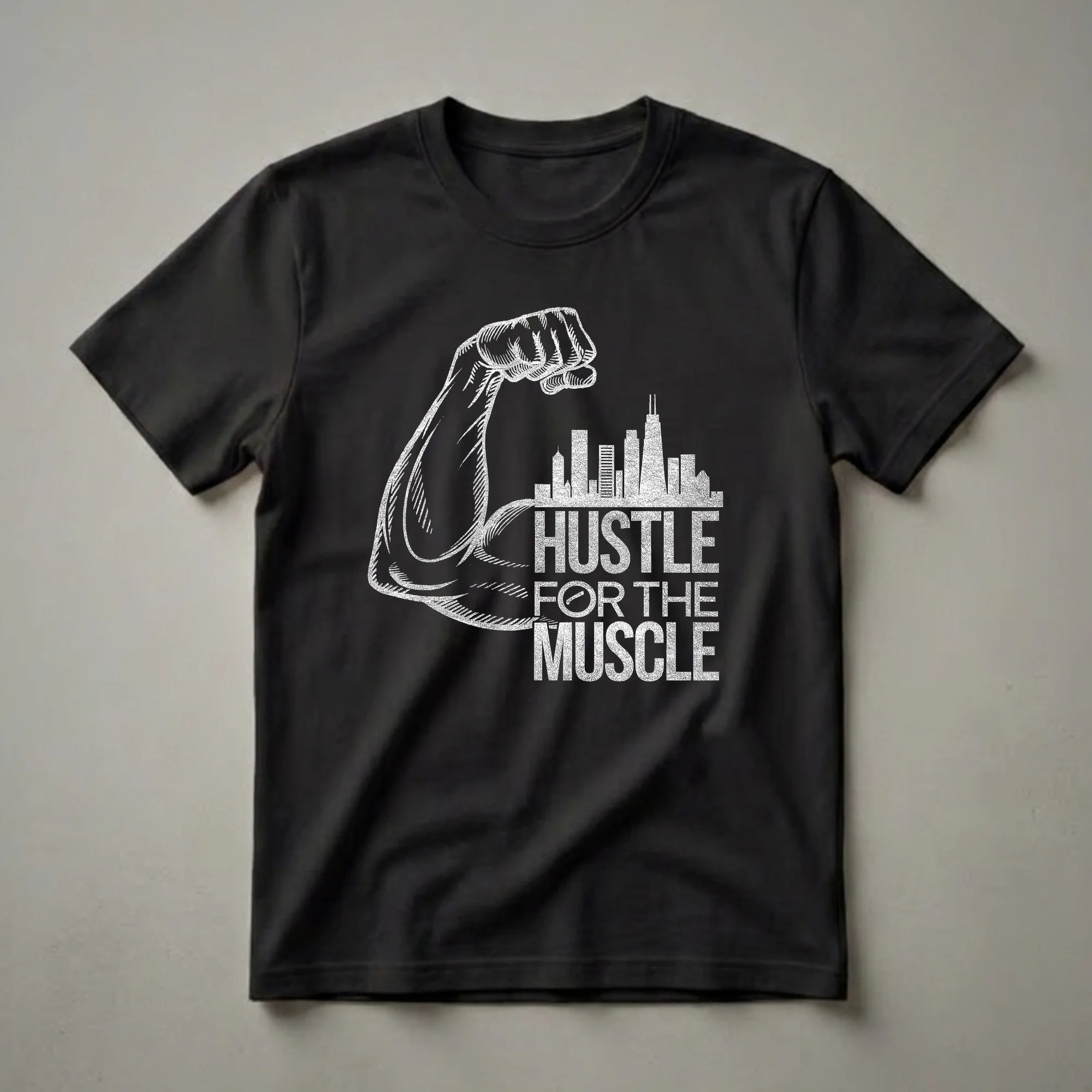 Black t-shirt with a white graphic design of a flexed bicep, a city skyline, and the motivational phrase 'Hustle for the Muscle'.