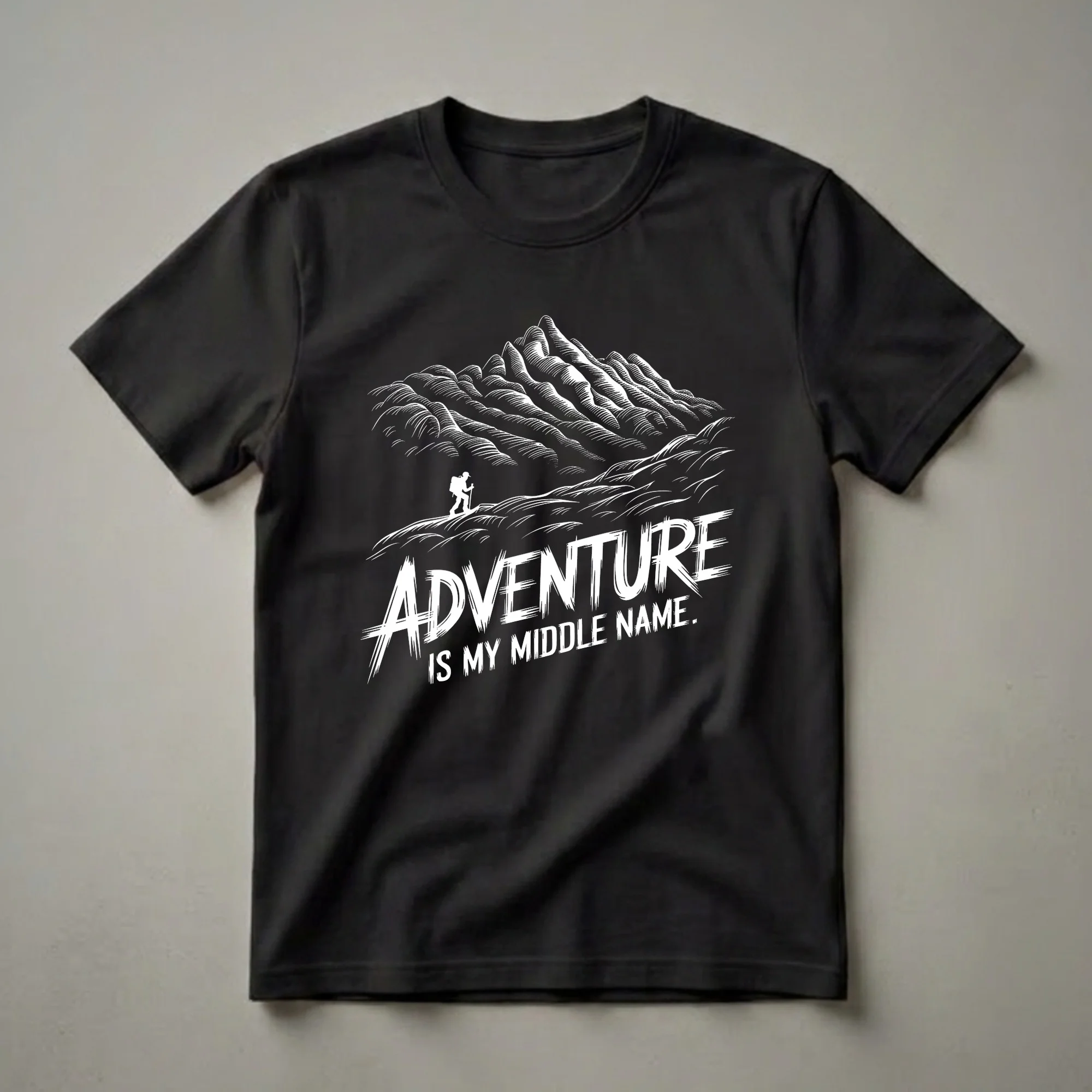 Black t-shirt with a white graphic design of a mountain range and a hiker, featuring the text 'Adventure is My Middle Name.'