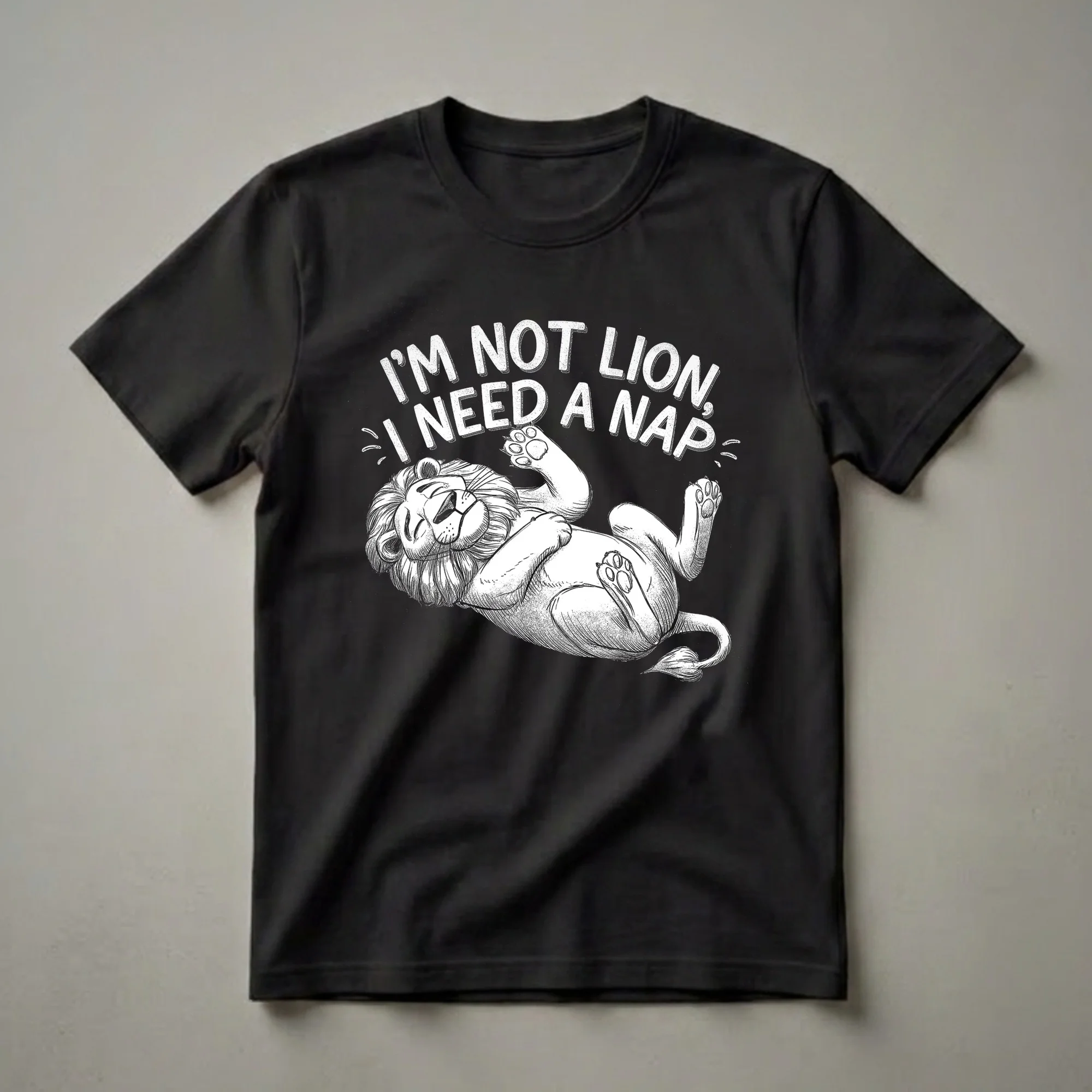 Black t-shirt with a white graphic illustration of a lion lying on its back with text above that reads 'I'M NOT LION, I NEED A NAP'.