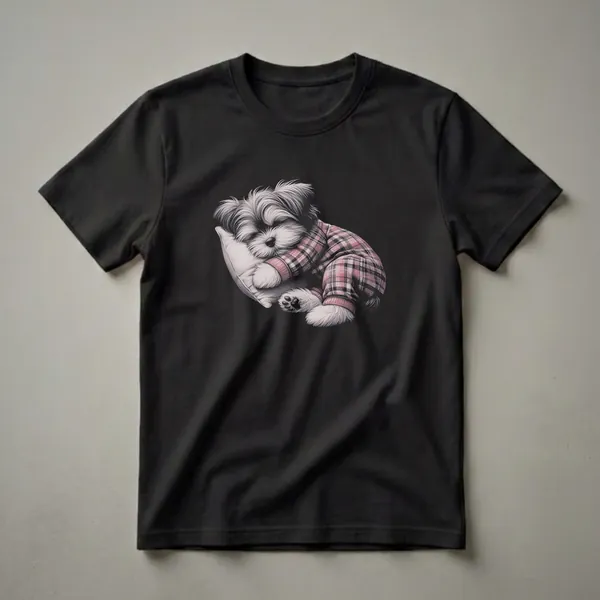 Black t-shirt featuring a detailed pencil sketch of a small Morkie dog wearing red and white plaid pajamas and sleeping soundly on a light-colored pillow.