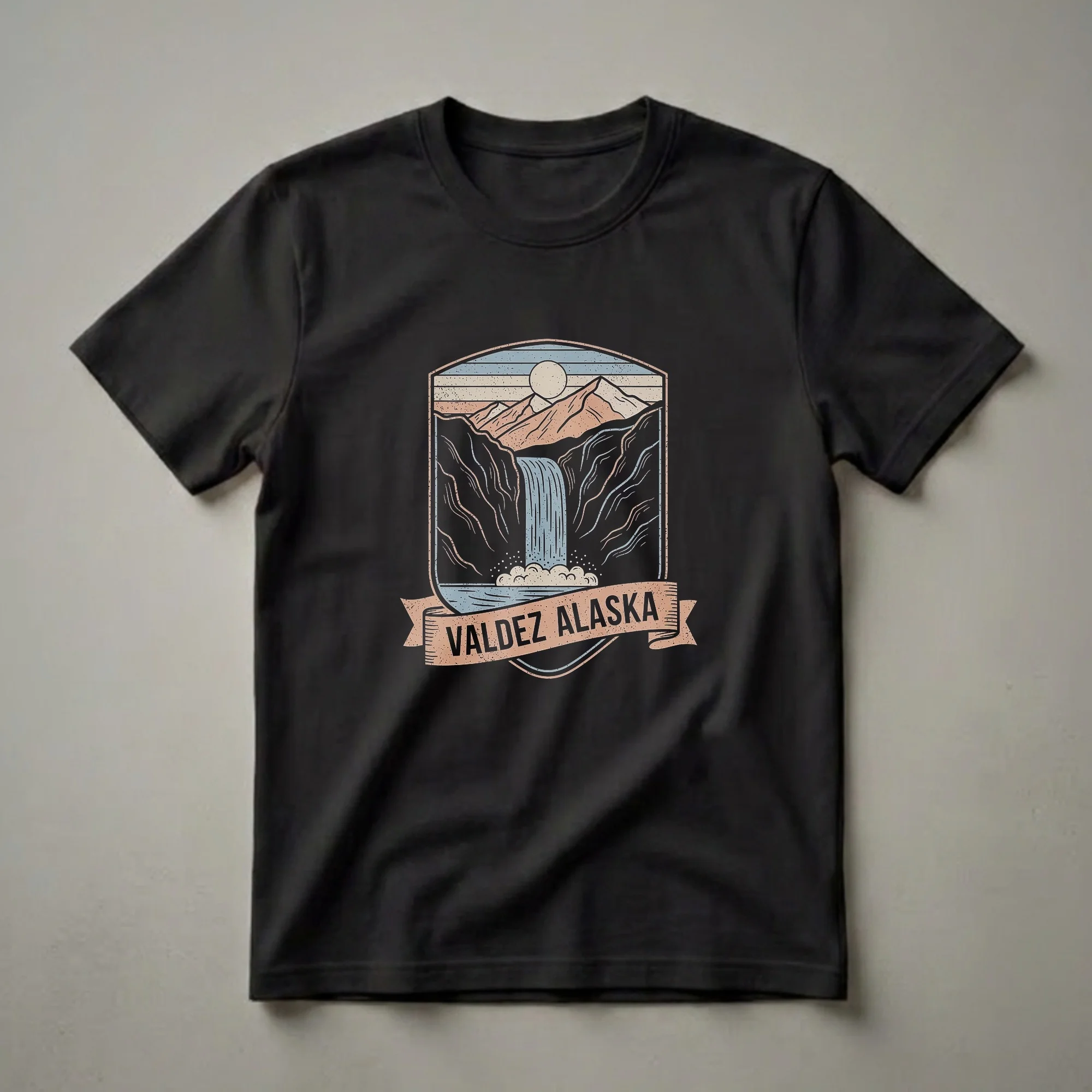A retro graphic t-shirt design featuring a badge with a waterfall, mountains, and the text 'VALDEZ ALASKA'.