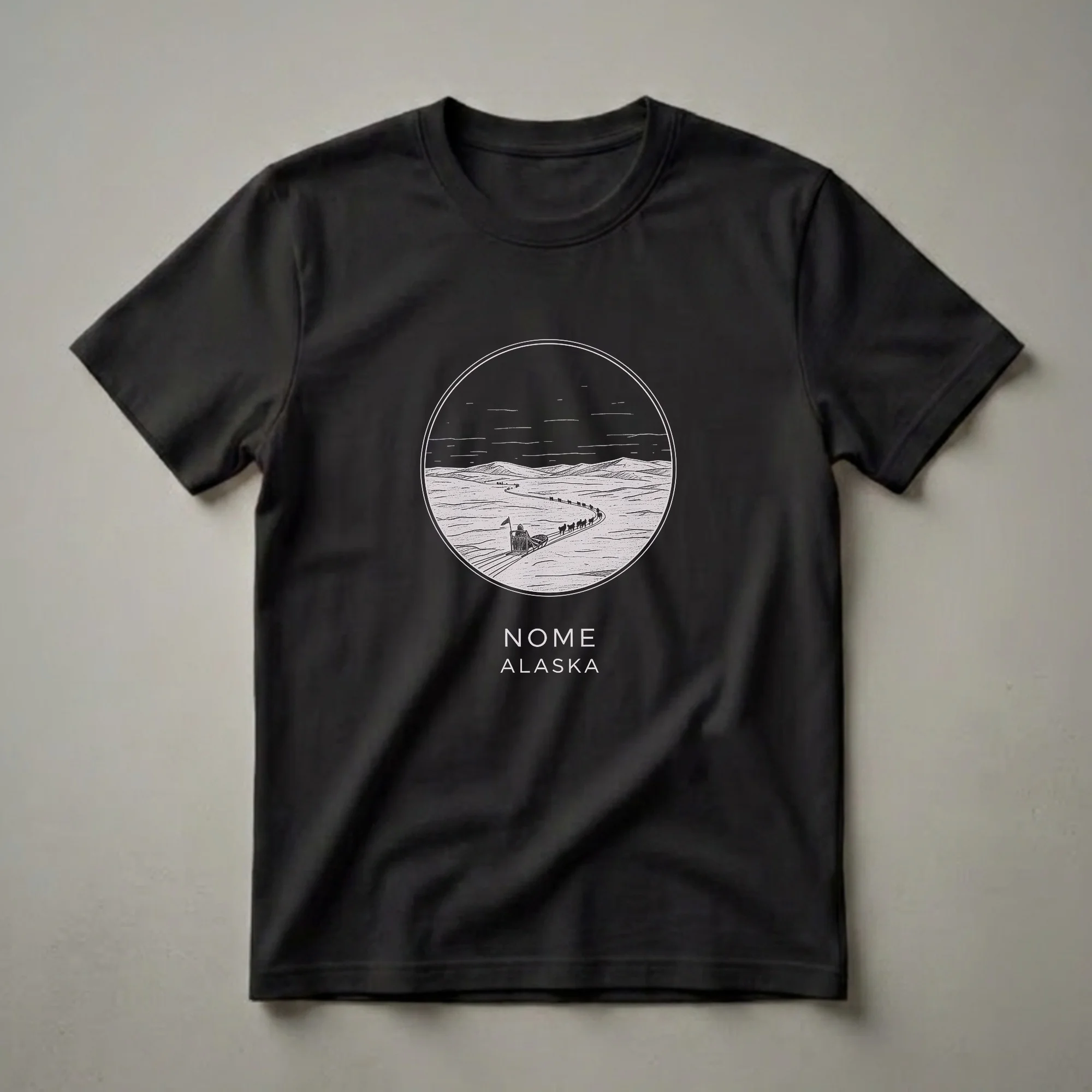 Black t-shirt with a circular sketch art design depicting a dog sled team on a snowy landscape, with 'NOME ALASKA' text below.