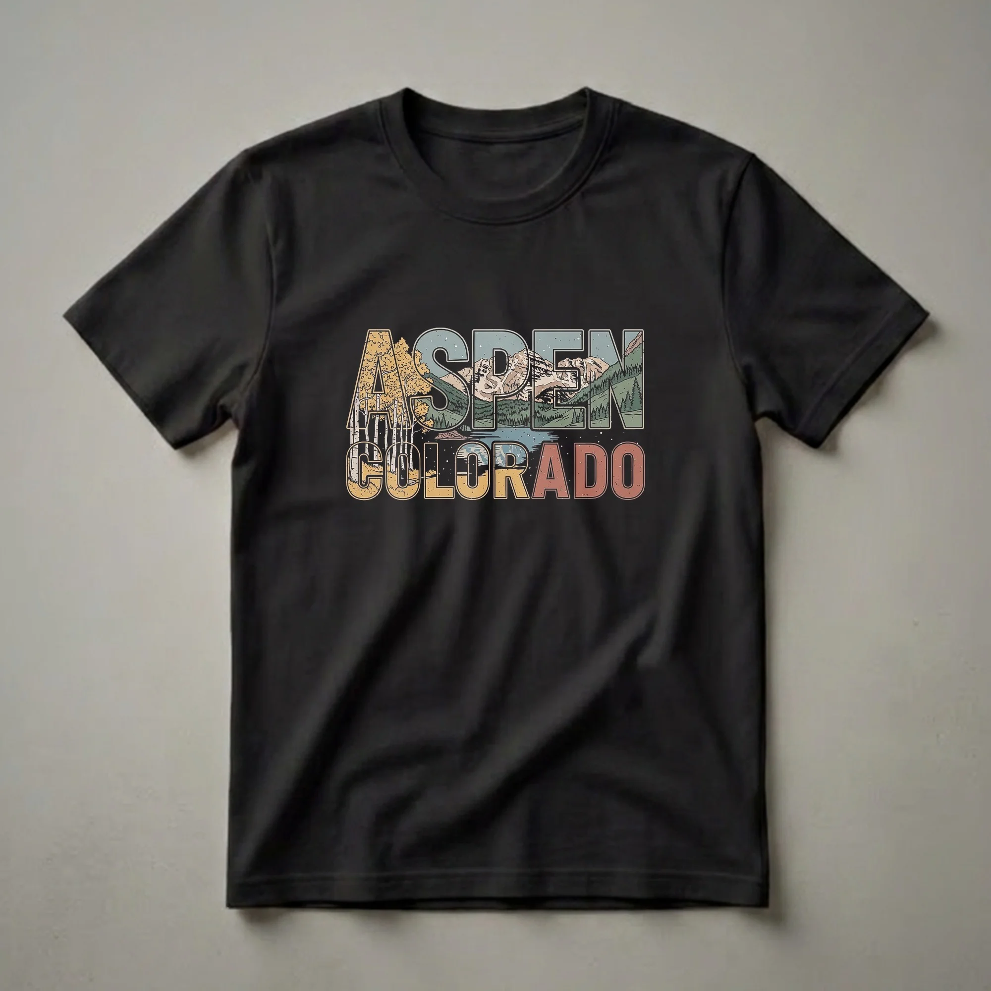 Black t-shirt with a retro graphic design that says ASPEN filled with aspen trees and mountains, and COLORADO filled with a lake and mountains.