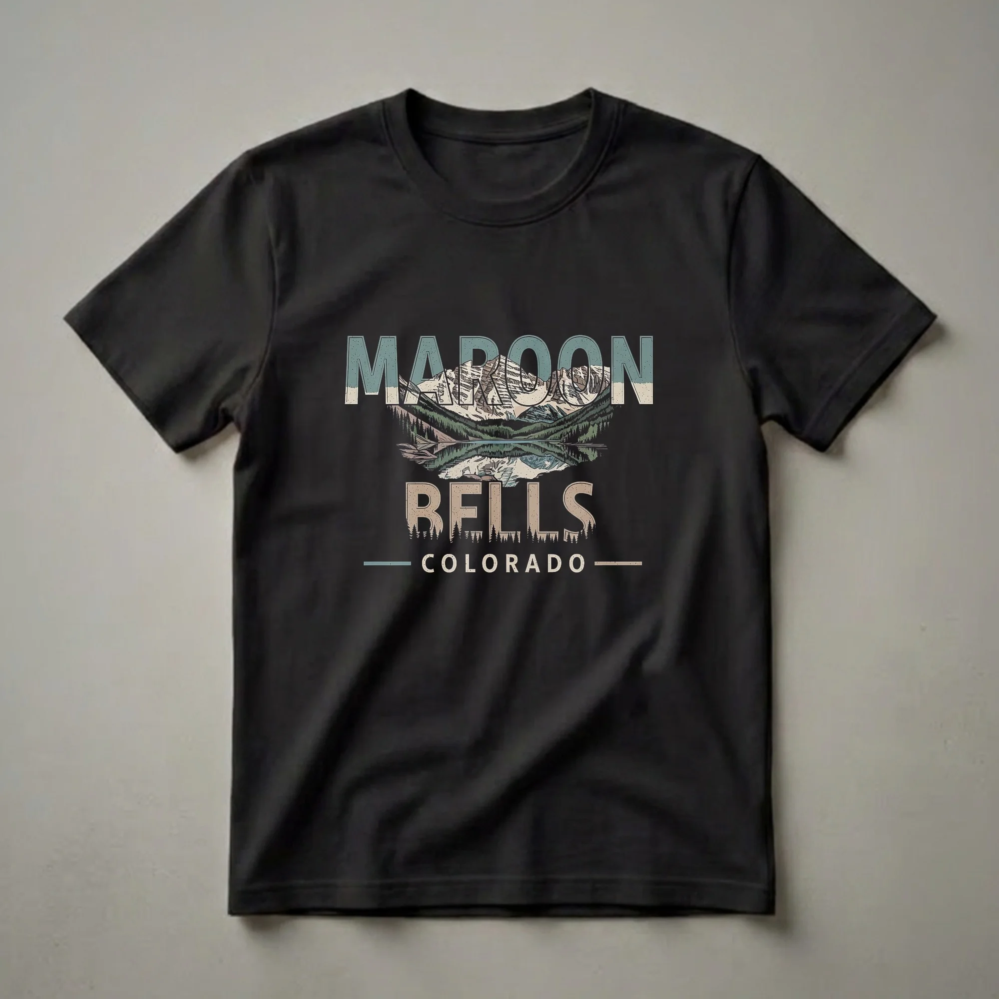 Black t-shirt with a retro graphic design of the Maroon Bells mountains reflected in a lake, with text reading 'MAROON BELLS COLORADO'.